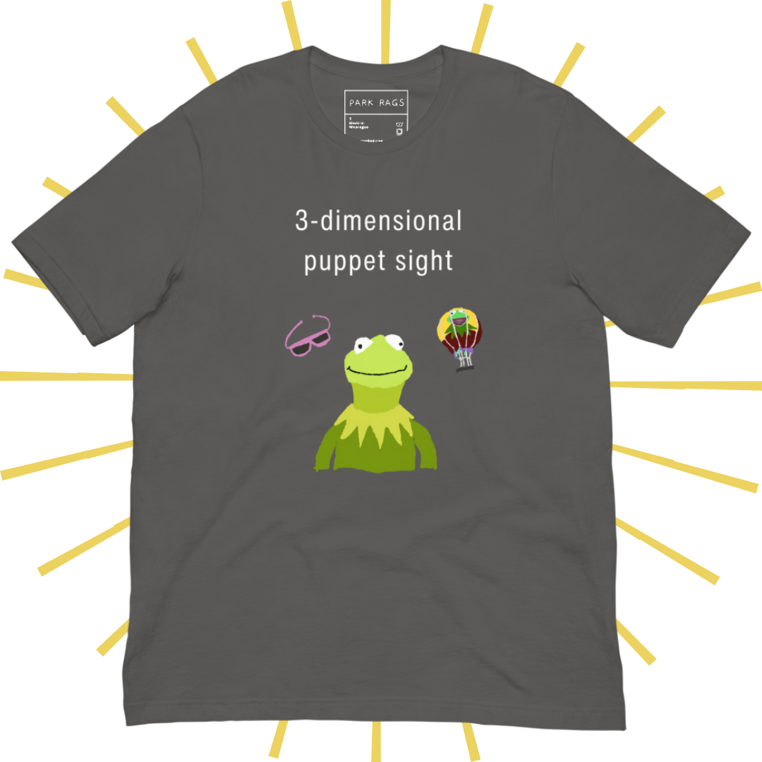 Front side of a medium grey T-shirt with plain white text reading "3-dimensional puppet sight". Below that are three shakily rendered drawings, as if done on MS Paint. The most prominent drawing in the center is Kermit the Frog from the chest up, with one of his beady eyes slightly askew. To the left of his face is a pair of the pink 3D glasses given to guests at 3-dimensional puppet sight (aka Muppet*Vision 3D). To Kermit's right is a splotchy rendering of the hot air balloon outside the attraction.