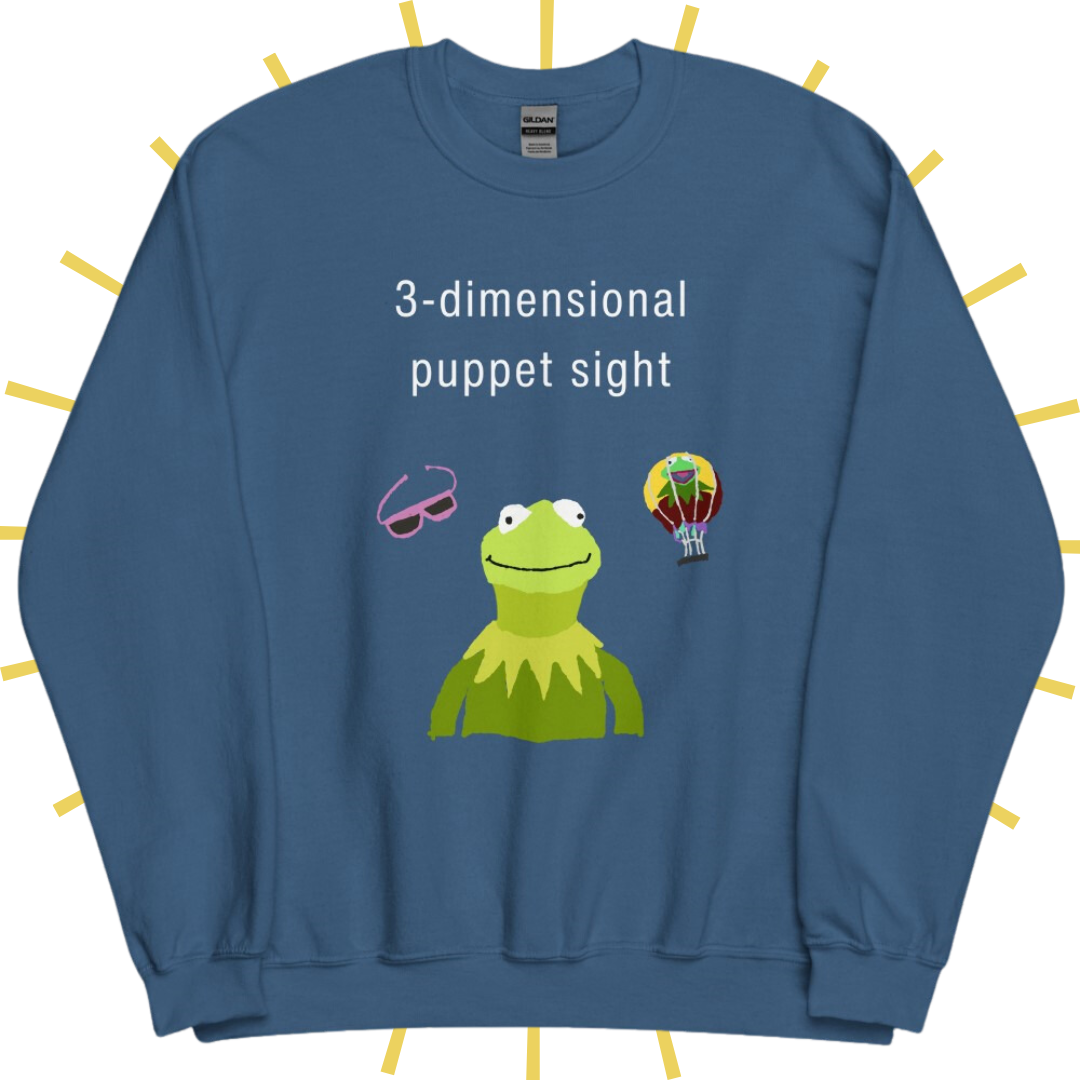 Front side of a dusty blue sweatshirt with plain white text reading "3-dimensional puppet sight". Below that are three shakily rendered drawings, as if done on MS Paint. The most prominent drawing in the center is Kermit the Frog from the chest up, with one of his beady eyes slightly askew. To the left of his face is a pair of the pink 3D glasses given to guests at 3-dimensional puppet sight (aka Muppet*Vision 3D). To Kermit's right is a splotchy rendering of the hot air balloon outside the attraction.