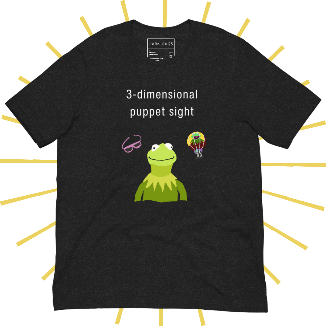 Front side of a dark grey heather T-shirt with plain white text reading "3-dimensional puppet sight". Below that are three shakily rendered drawings, as if done on MS Paint. The most prominent drawing in the center is Kermit the Frog from the chest up, with one of his beady eyes slightly askew. To the left of his face is a pair of the pink 3D glasses given to guests at 3-dimensional puppet sight (aka Muppet*Vision 3D). To Kermit's right is a splotchy rendering of the hot air balloon outside the attraction.