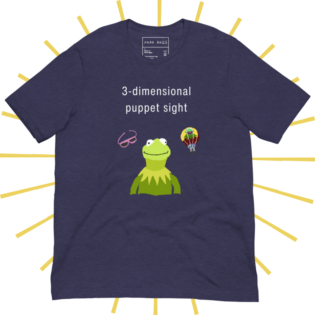 Front side of a purple T-shirt with plain white text reading "3-dimensional puppet sight". Below that are three shakily rendered drawings, as if done on MS Paint. The most prominent drawing in the center is Kermit the Frog from the chest up, with one of his beady eyes slightly askew. To the left of his face is a pair of the pink 3D glasses given to guests at 3-dimensional puppet sight (aka Muppet*Vision 3D). To Kermit's right is a splotchy rendering of the hot air balloon outside the attraction.